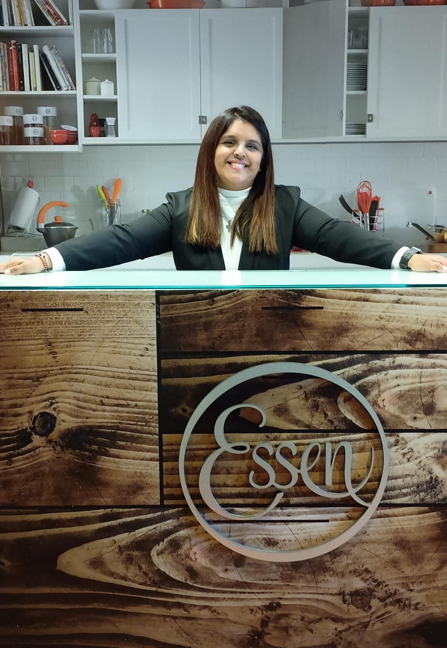 Sofi Romano con los brazos abiertos detrás de una barra con el logo de Essen